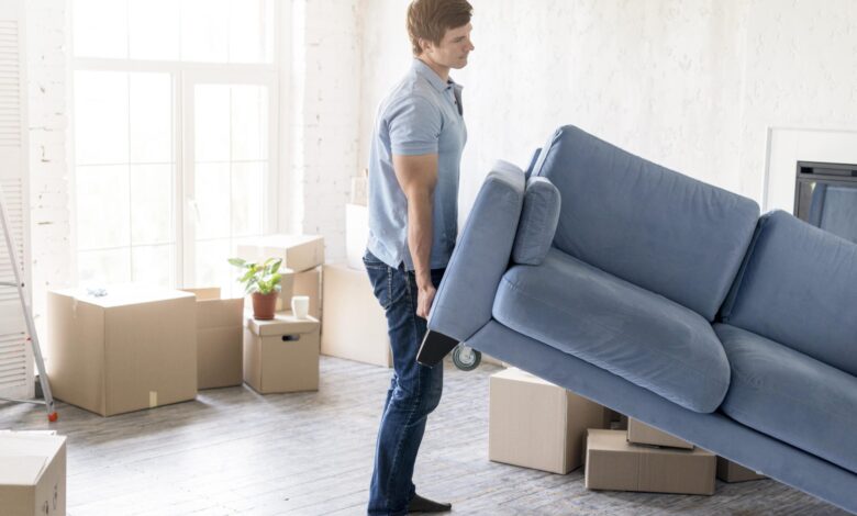 side-view-man-handling-couch-while-preparing-move-out - مرينا لتجارة اثاث مستعمل